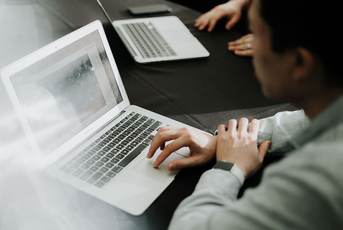 Man at meeting reviewing on a laptop